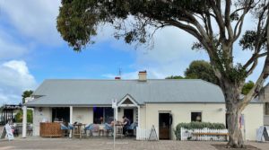 Two people sit outside of Woodsoak Wines cellar door in Robe