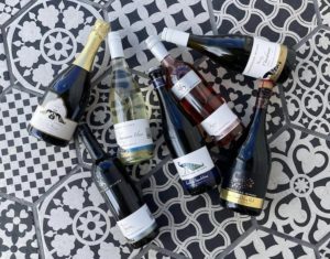 7 bottles of different Woodsoak Wines that won medals against a black and white mosaic backdrop